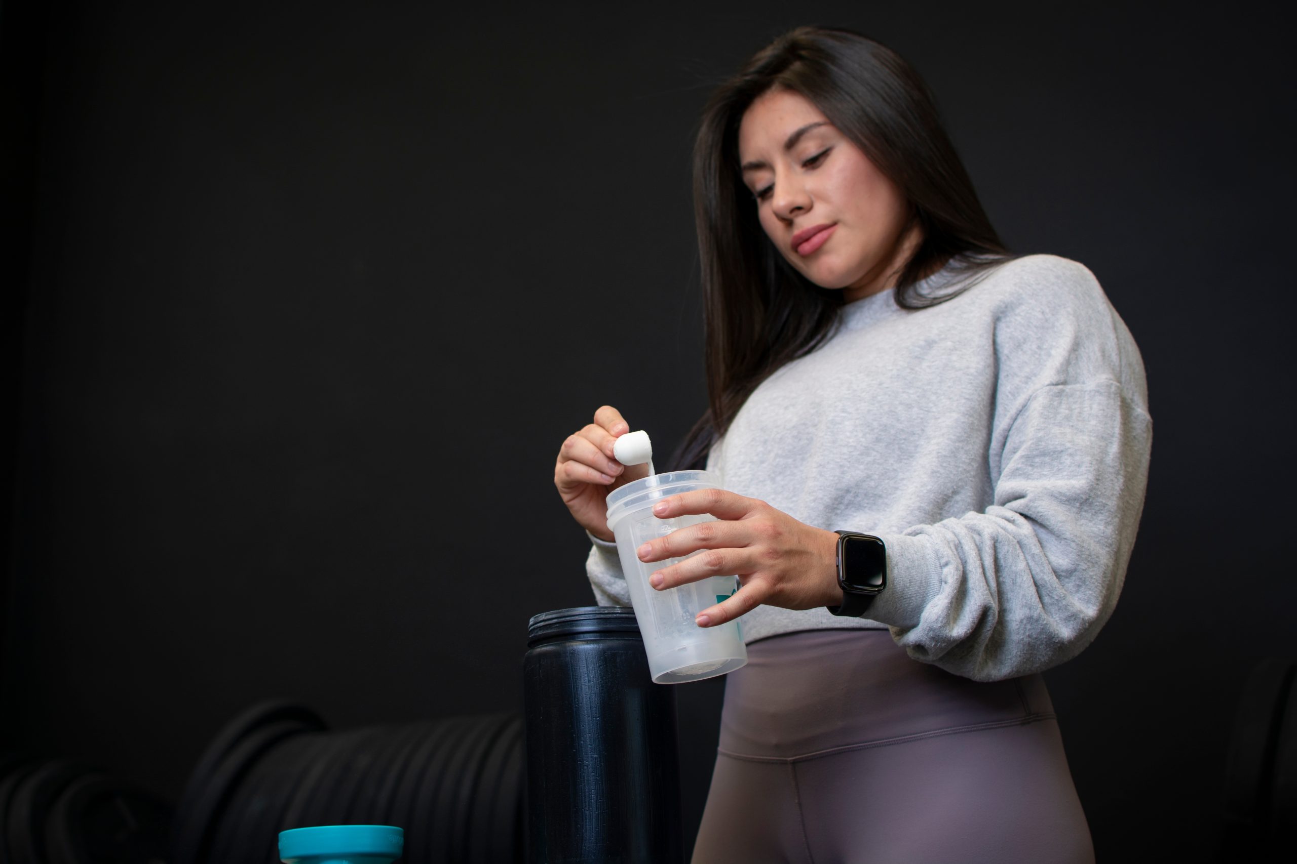 Woman over 40 preparing creatine supplement as part of her midlife nutrition routine for muscle strength and bone health